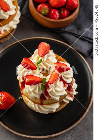 Victoria sponge cake with strawberries, jam and whipped cream on dark background. Copy space. Victoria sponge cake with strawberries, jam and whipped cream on dark background. Copy space. 45624349