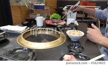 Korean barbecue grill. people cook and eat dishes cooked on a Korean grill in a restaurant. close-up Korean barbecue grill. people cook and eat dishes cooked on a Korean grill in a restaurant. close-up 45624605