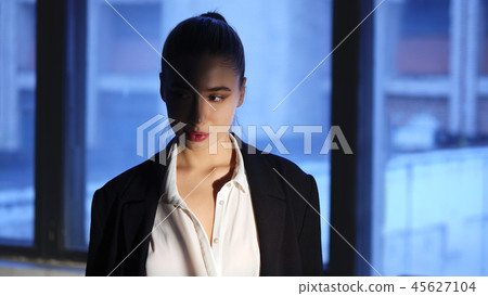 Girl in dark room highlighted with spotlight 45627104