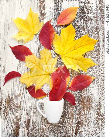 Creative arrangement autumn leaves and coffee cup Creative arrangement autumn leaves and coffee cup 45628940