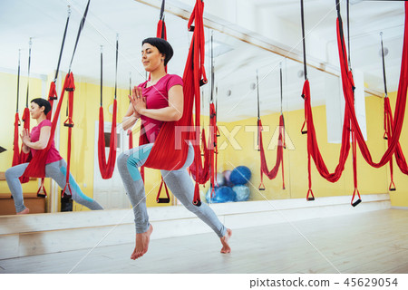 Young beautiful woman practicing yoga Fly with a hammock in the bright studio. Flying, fitness 45629054