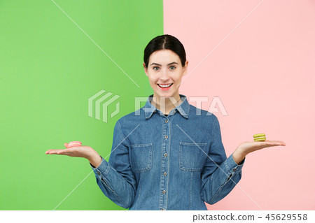 Young beautiful woman holding macaroons pastry in her hands 45629558