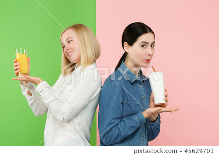 Diet. Dieting concept. Healthy Food. Beautiful Young Women choosing between fruit orange juice and 45629701