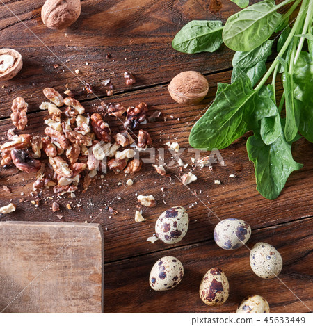 Fresh spinach, quail eggs, pieces of nuts on a wooden table with copy space. Healthy Salad Fresh spinach, quail eggs, pieces of nuts on a wooden table with copy space. Healthy Salad 45633449