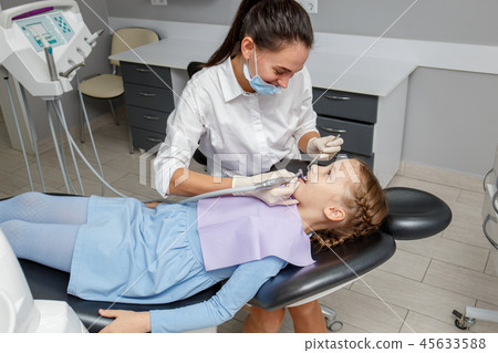 Child girl having professional dental cleaning Child girl having professional dental cleaning 45633588