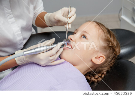 Child girl having professional dental cleaning Child girl having professional dental cleaning 45633589