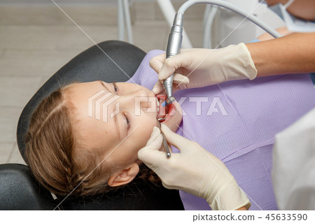 Child girl having professional dental cleaning Child girl having professional dental cleaning 45633590