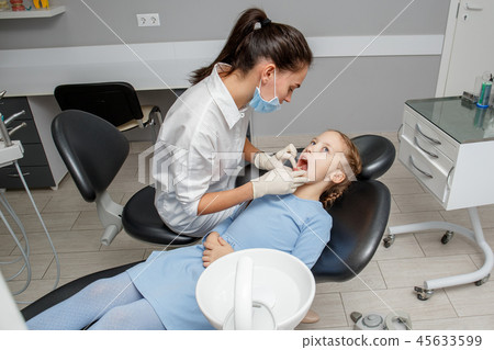 Child having dental check up by specialist Child having dental check up by specialist 45633599