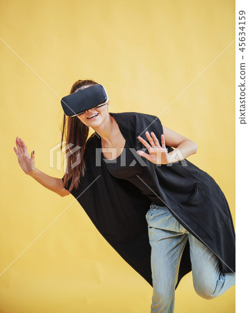 Happy woman gets experience of using VR-glasses virtual reality headset Happy woman gets experience of using VR-glasses virtual reality headset 45634159