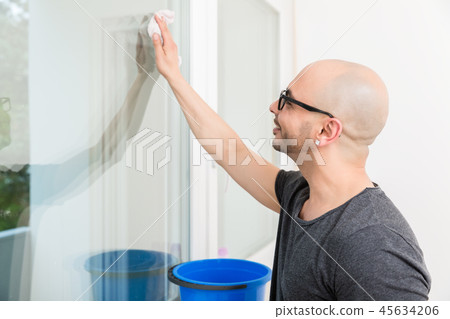 Man washing the window glass with cloth 45634206
