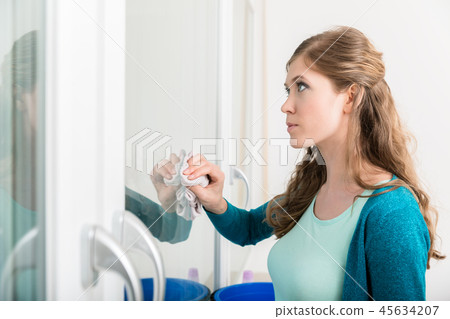 Woman cleaning the door glass with cloth Woman cleaning the door glass with cloth 45634207