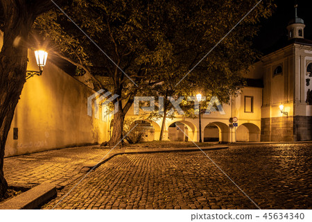Narrow cobbled street in old medieval town with illuminated houses by vintage street lamps, Novy Narrow cobbled street in old medieval town with illuminated houses by vintage street lamps, Novy 45634340
