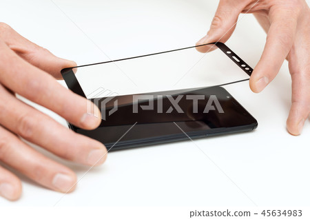 A man is holding a protective smartphone glass. A man is holding a protective smartphone glass. 45634983