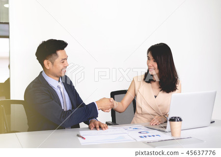 Businessman and woman shake hand to deal business 45637776