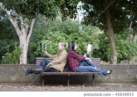 A couple sitting on a park bench A couple sitting on a park bench 45639053