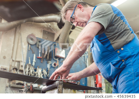 Metalworker man in his workshop working on project 45639435