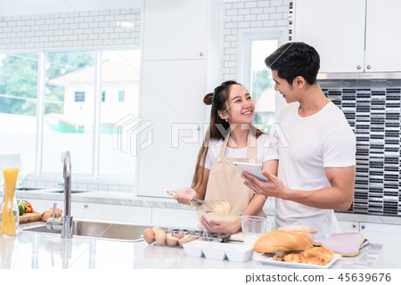 Asian couples cooking and baking cake together in kitchen room a Asian couples cooking and baking cake together in kitchen room a 45639676