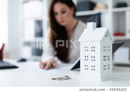 A young girl sitting at the table. Photo with depth of field, highlighted focus on home and keys. A young girl sitting at the table. Photo with depth of field, highlighted focus on home and keys. 45640262
