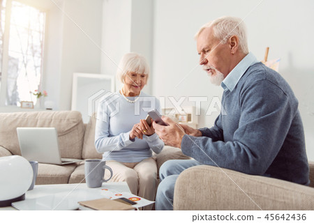 Married aging couple choosing photos on the gadget 45642436