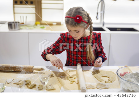 Pretty little girl making cookies on white kitchen Pretty little girl making cookies on white kitchen 45642710