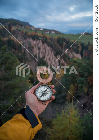 A first-person view of a man's hand with retro compass. 45642916