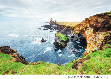 Cape Dyrholaey at southern Iceland. Altitude 120 m, and mean hill island with a door opening. 45642927