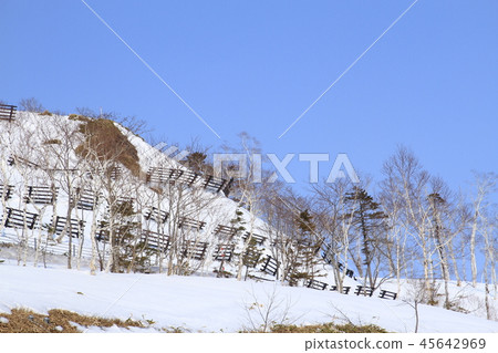 Avalanche fence, snowy country, blue sky 45642969