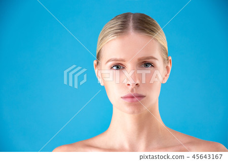 Beautiful Woman Face. Beauty Portrait of young woman blonde on blue background. Perfect Fresh Skin Beautiful Woman Face. Beauty Portrait of young woman blonde on blue background. Perfect Fresh Skin 45643167