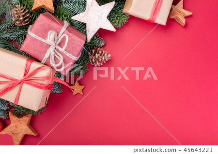 Christmas composition. Christmas red decorations, fir tree branches with toys gift boxes on red 45643221