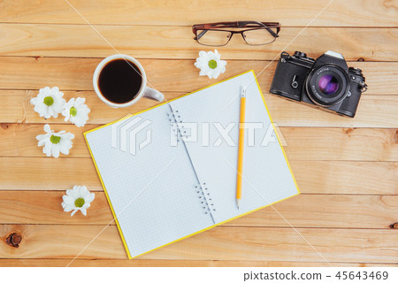 On wooden background notebook pencil, coffee and flowers. On wooden background notebook pencil, coffee and flowers. 45643469