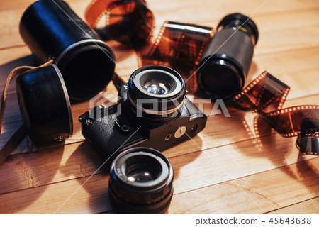 Old photo film and analog camera on table. Roll of photographic . Beautiful vintage design. 45643638