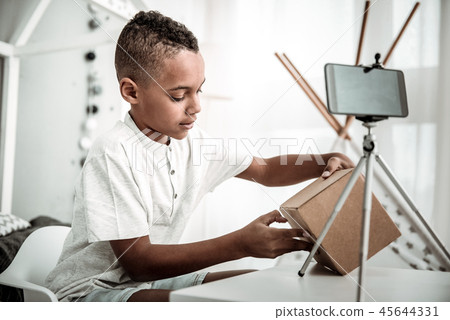 Nice cute boy opening a cardboard box 45644331