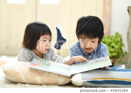 Brother and sister reading in the living room 45645264