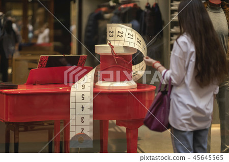 Shop window, display commercial equipment, decorative sewing needle and coil with red thread. Girl Shop window, display commercial equipment, decorative sewing needle and coil with red thread. Girl 45645565