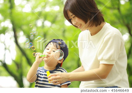 Parents and children playing with soap bubbles 45646649