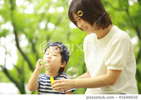 Parents and children playing with soap bubbles 45646650