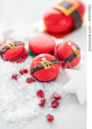 Funny cookie in the form red santa belly on gray table sprinkled with snow. Modern european French Funny cookie in the form red santa belly on gray table sprinkled with snow. Modern european French 45654901