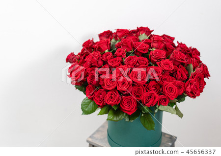 Big luxury bright bouquet on wooden table. One hundred of garden red roses. Color passionately 45656337