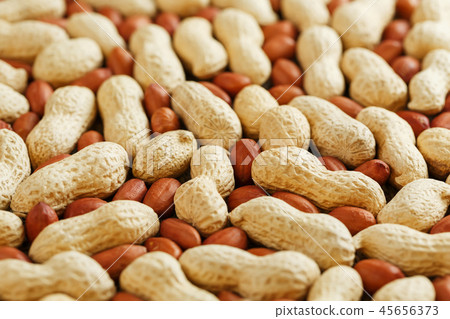 Roasted peanuts in a shell and peeled on a brown  45656373