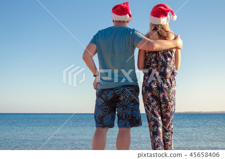 man hugging woman in christmas hats man hugging woman in christmas hats 45658406