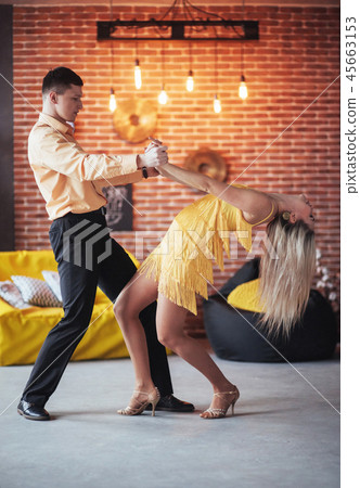 Young couple dancing latin music: Bachata, merengue, salsa. Two elegance pose on cafe with brick 45663153