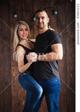 Young couple dancing latin music: Bachata, merengue, salsa. Two elegance pose on cafe with brick 45663223