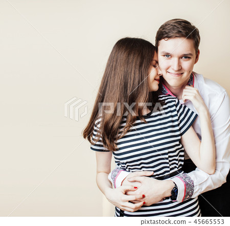 couple of happy smiling teenagers students, warm colors having a couple of happy smiling teenagers students, warm colors having a 45665553
