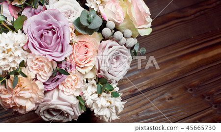 A bouquet of flowers on a wooden brown background. Copy space A bouquet of flowers on a wooden brown background. Copy space 45665730