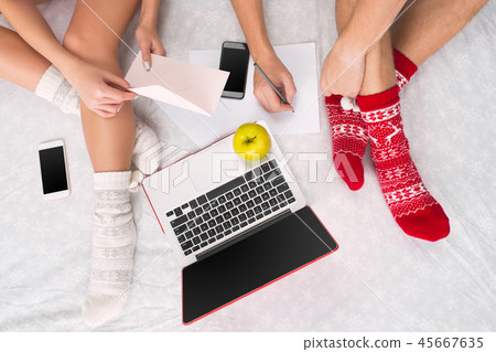 caucasian couple at home using internet technology. Laptop and phone for people sitting on the floor caucasian couple at home using internet technology. Laptop and phone for people sitting on the floor 45667635