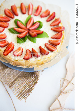 Very beautiful summer cheesecake decorated with strawberries - stands on a white wooden table Very beautiful summer cheesecake decorated with strawberries - stands on a white wooden table 45668821