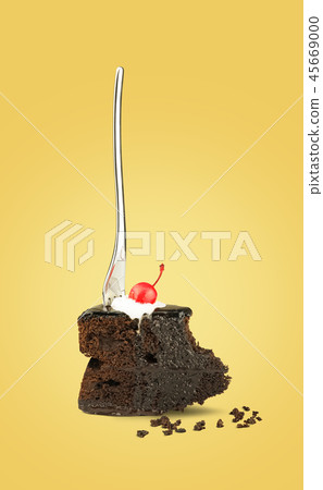 Chocolate cake with fork on yellow background Chocolate cake with fork on yellow background 45669000