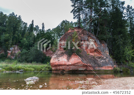 Summer landscape and red stone cliff of Amata river, Latvia, Europe. Summer landscape and red stone cliff of Amata river, Latvia, Europe. 45672352