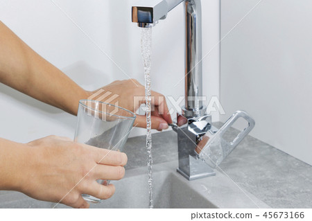 Hand holding a glass of water poured Hand holding a glass of water poured 45673166