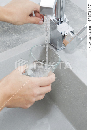 Hand holding a glass of water poured Hand holding a glass of water poured 45673167